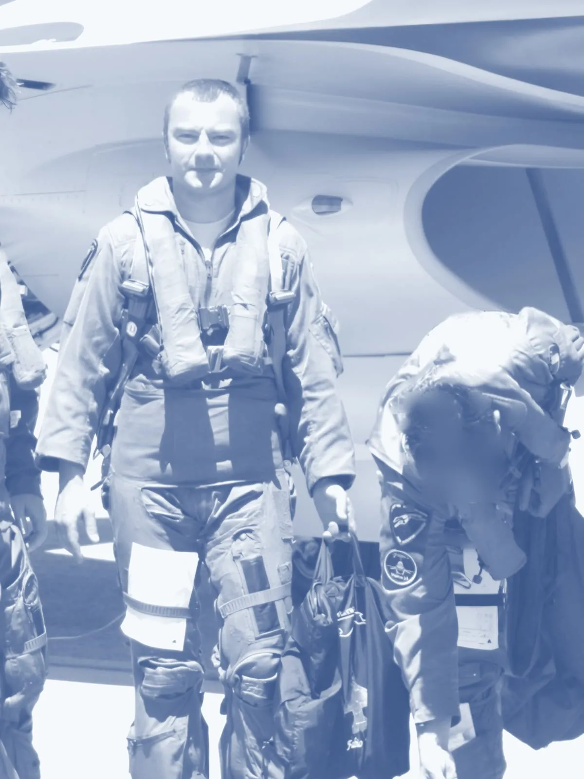 Fabio Masci da giovane, in tuta di volo e imbracatura davanti a un caccia, accanto ad altri piloti