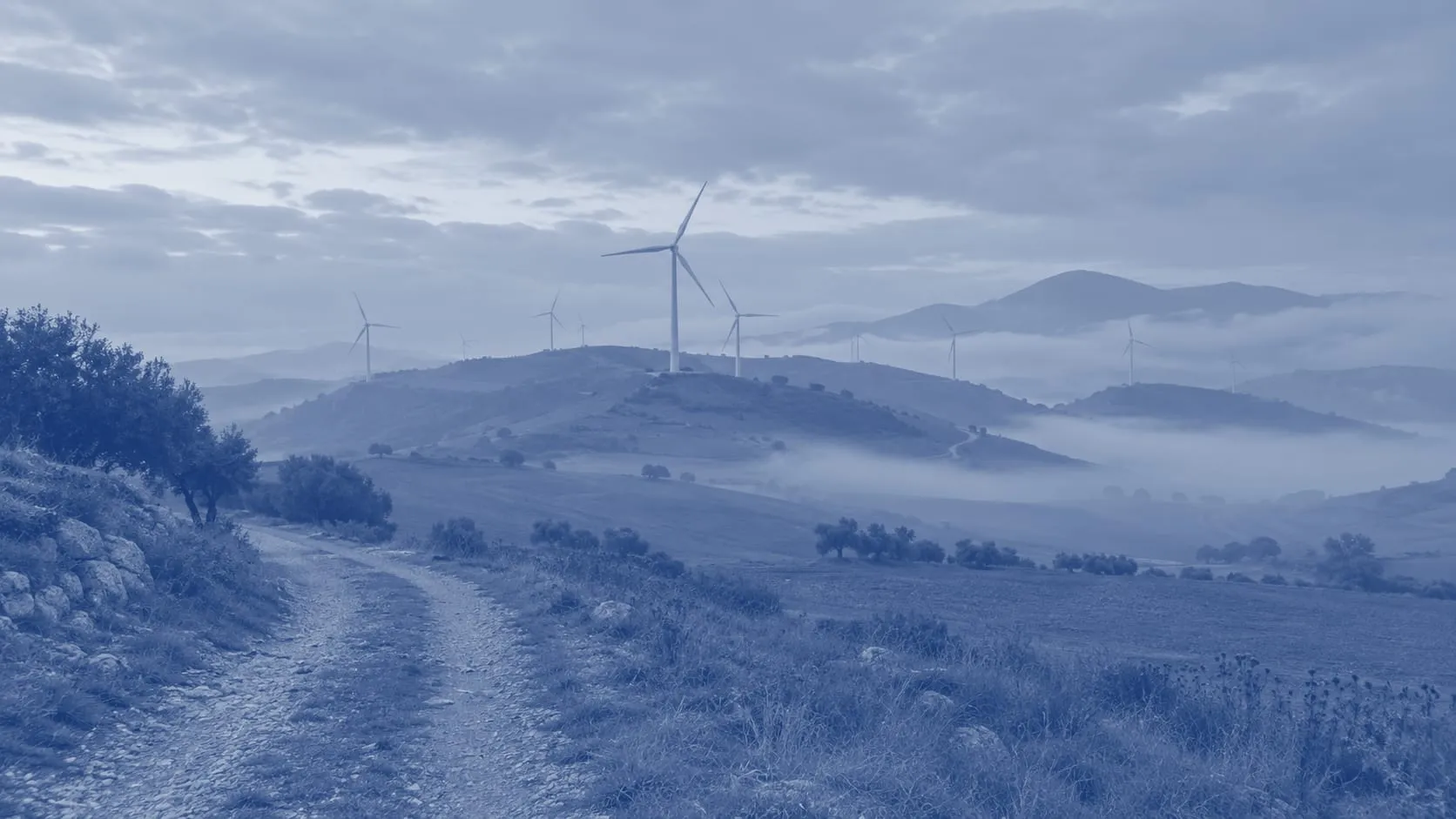 Pale eoliche su colline ondulate nella nebbia del mattino, una strada di campagna in primo piano, un'illustrazione stampata in duotono blu
